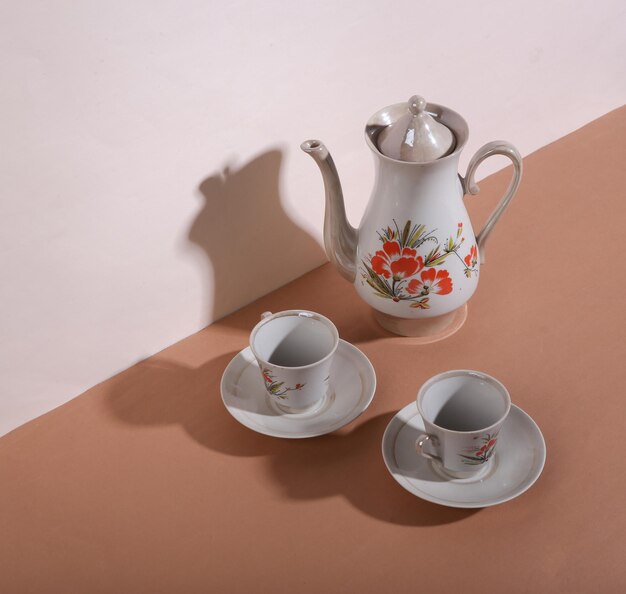 Bodegón creativo Tetera y tazas retro sobre fondo marrón beige Minimalismo Sombra de moda