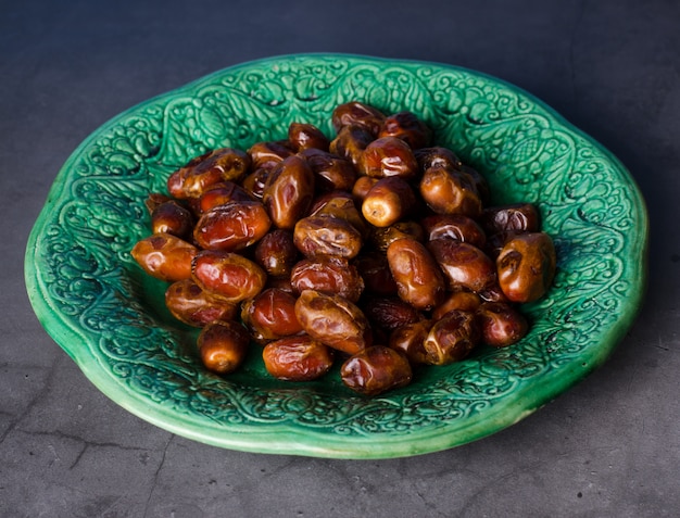 Foto bodegón con dulces frutos de palmera datilera en un vintage piala, ramadan, ramadan, comida tradicional.