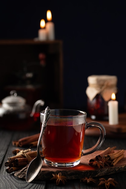 Bodegón con especias y té caliente en un vaso.