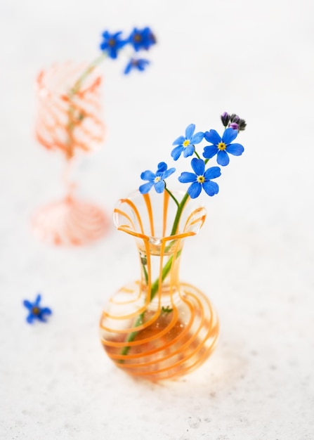 Bodegón con flores azules no me olvides en mini jarrones de cristal