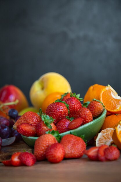 Bodegón de frutas frescas de temporada de tonos rojizos