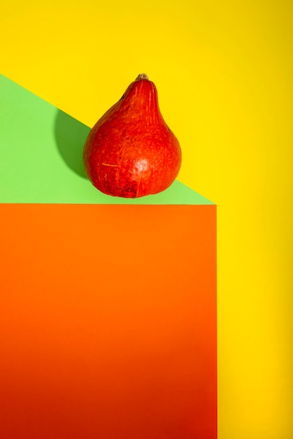 Bodegón geométrico con calabaza naranja sobre un fondo de color