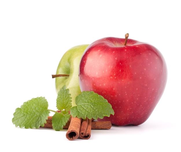 Bodegón de hojas de menta y palitos de canela de manzanas rojas y verdes