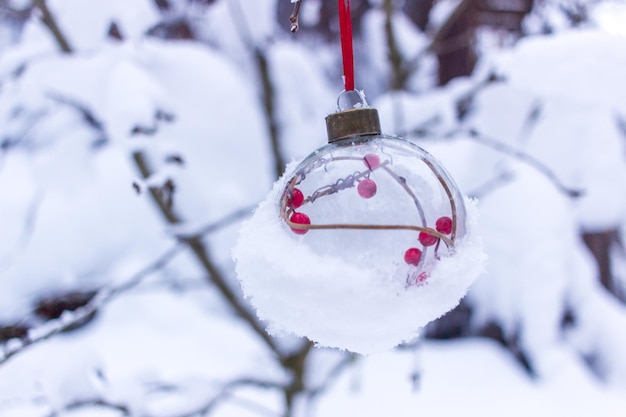 Foto bodegón de invierno bola de año nuevo con nieve en el fondo
