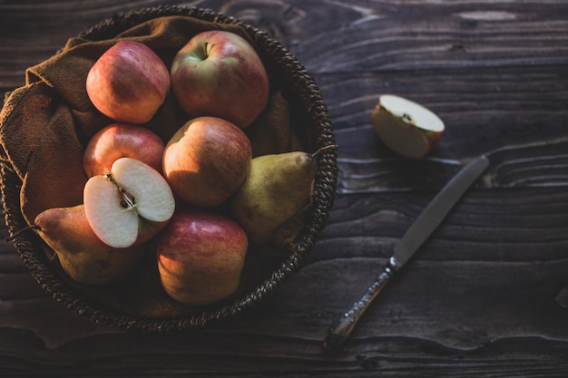 Bodegón manzanas en una canasta de mimbre sobre una mesa de madera