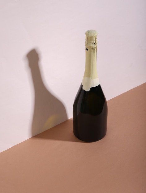 Foto bodegón moderno creativo botella de champán sobre fondo marrón beige minimalismo sombra de moda