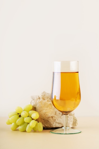 Bodegón moderno vaso de vino blanco o jugo y uvas