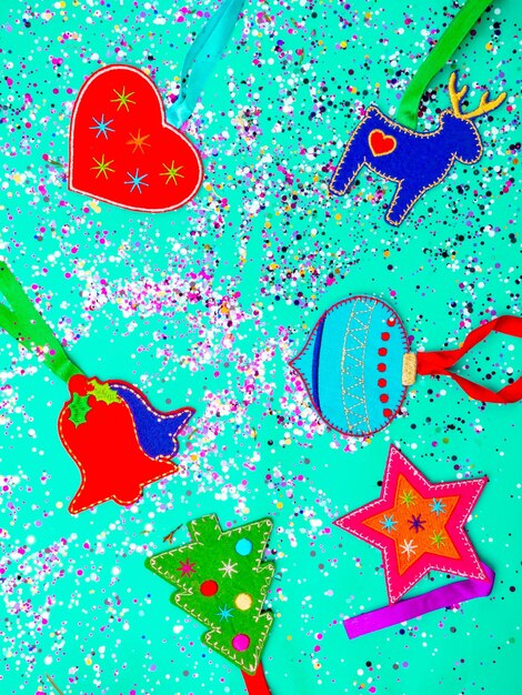 Bodegón de Navidad coloridos juguetes y confeti sobre un moderno fondo verde menta