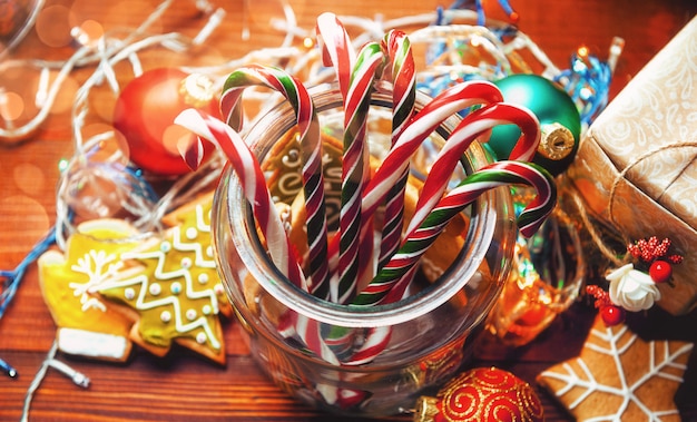 Bodegón navideño. Galletas de jengibre caseras, dulces de caña, sobre una superficie de madera.