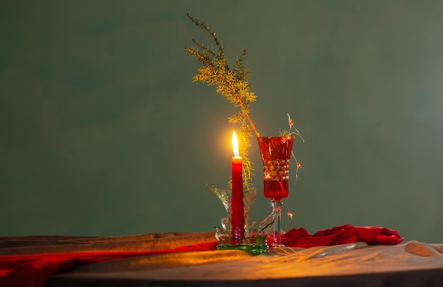 Bodegón navideño con velas encendidas y vidrios rotos en estilo antiguo