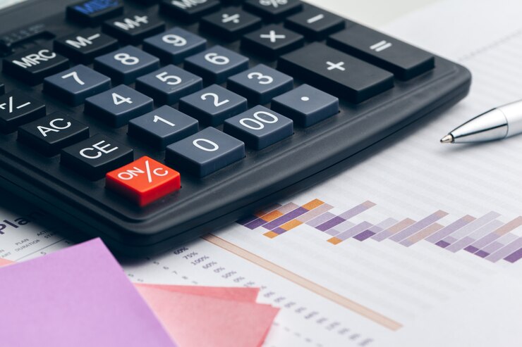 Foto bodegón de negocios con la calculadora en la mesa de oficina.