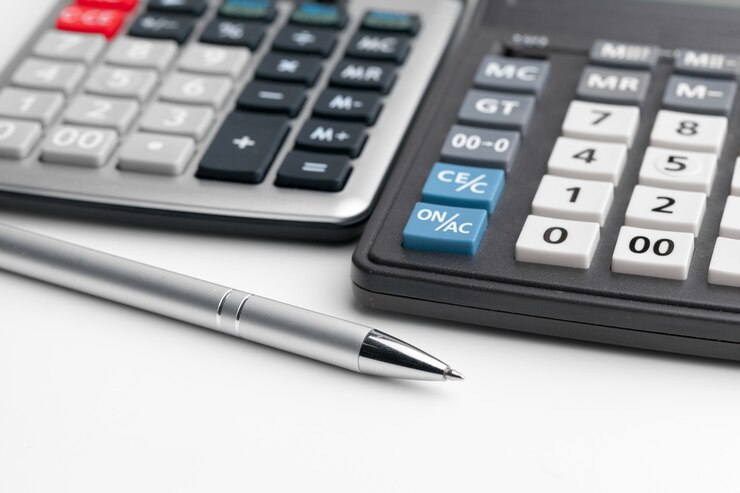 Foto bodegón de negocios con la calculadora en la mesa de oficina.