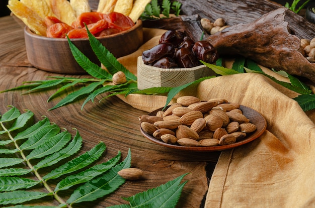 Bodegón de nueces y frutos secos en una mesa de madera con hojas de helecho