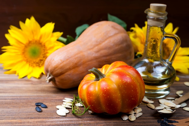 Bodegón otoñal con calabazas, aceite y girasoles.