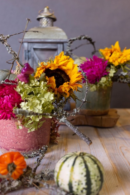 Bodegón otoñal con calabazas y flores.