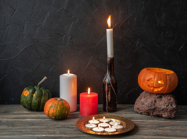 Foto bodegón otoñal con calabazas y velas en una mesa de madera