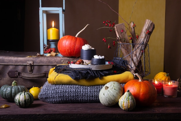 Foto bodegón otoñal con calabazas y velas.