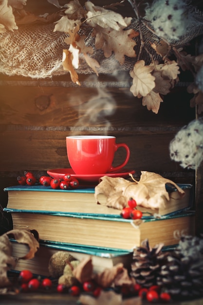 Bodegón otoñal con una taza de café, manzanas y hojas de otoño.