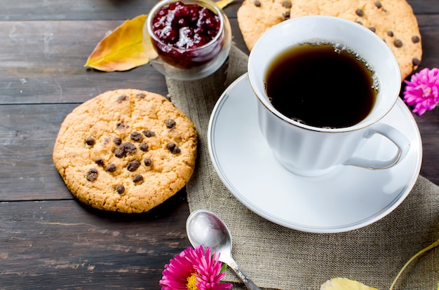 Bodegón otoñal con taza de té, galletas y hojas.