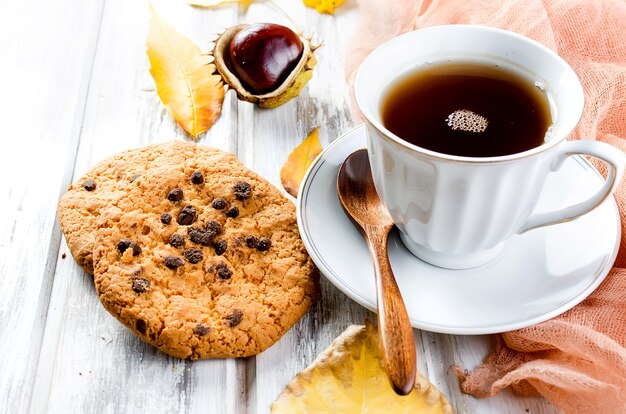 Foto bodegón otoñal con taza de té, galletas y hojas