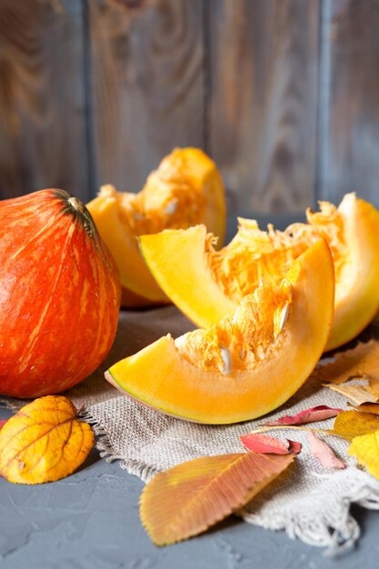 Bodegón de otoño Calabazas y hojas amarillas Trozos de calabaza picados Fondo de otoño