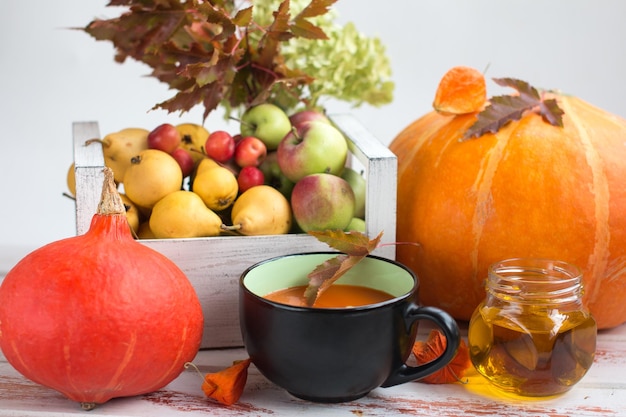 Bodegón de otoño con sopa de calabaza de verduras y follaje amarillento