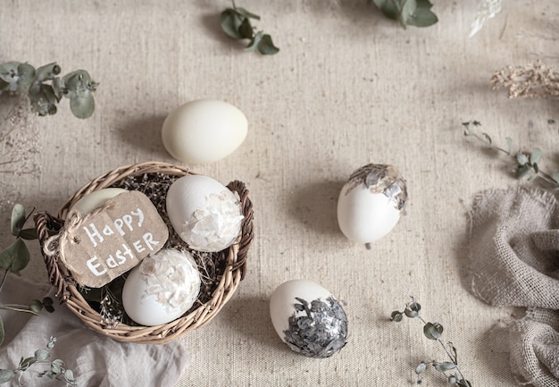 Bodegón de Pascua con huevos en una canasta de mimbre. Concepto de Pascua feliz.