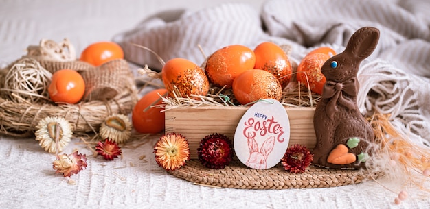 Bodegón de Pascua con huevos de naranja, decoración de vacaciones.