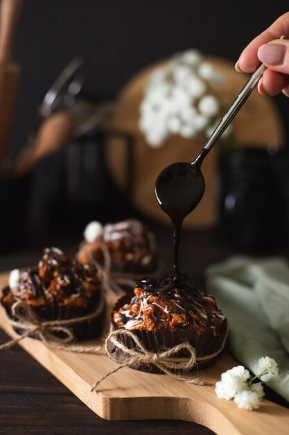 Bodegón con pasteles cubiertos con glaseado blanco y chocolate en la mesa de la cocina