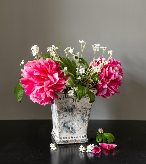 Bodegón con peonías rosas y flores silvestres