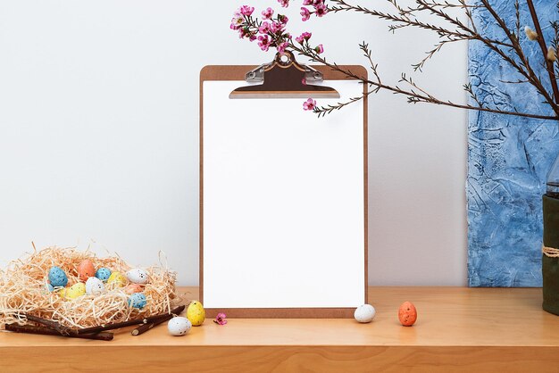 Bodegón de primavera Maqueta de marco de imagen en blanco sobre fondo de mesa de madera Composición de Pascua con sauce floreciente y flores de cera en jarrón