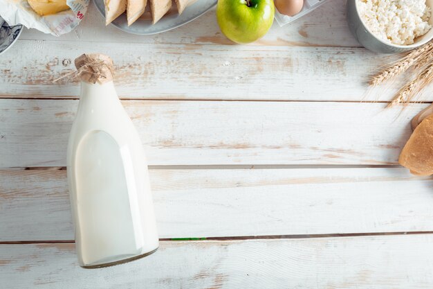 Foto bodegón con productos lácteos, leche, huevos, pan.