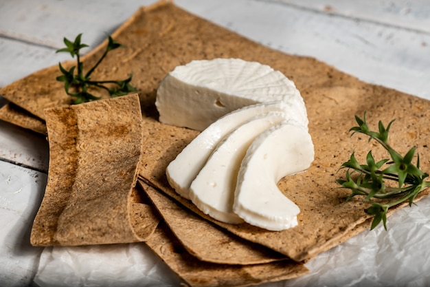 Bodegón con queso Adyghe en pan de pita y hojas de albahaca.