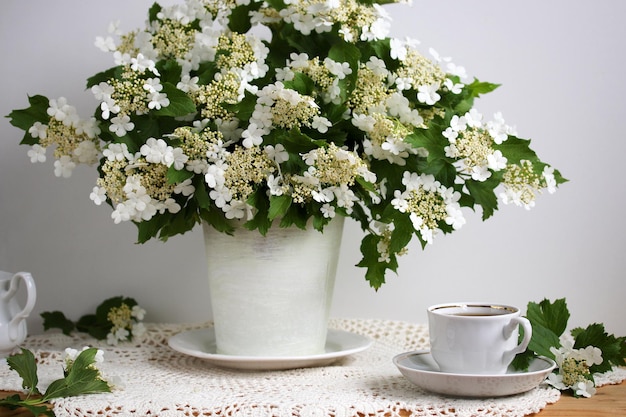 Bodegón con un ramo de ramas de viburnum en flor