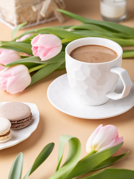 Bodegón romántico con una taza de cacao, macarons y tulipanes