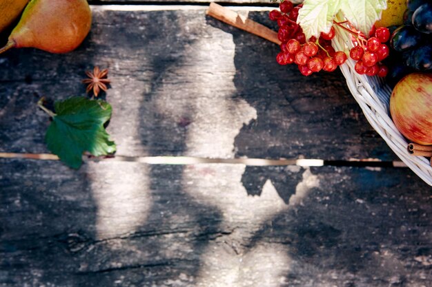 Bodegón rústico de otoño uvas peras viburnum y palitos de canela con decoraciones de mesa de madera de moda Concepto del Día de Acción de Gracias Fondo de otoño al aire libre