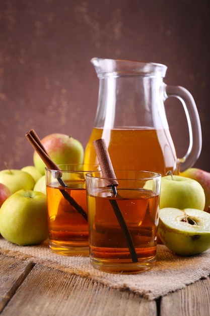 Bodegón con sidra de manzana y manzanas frescas en mesa de madera