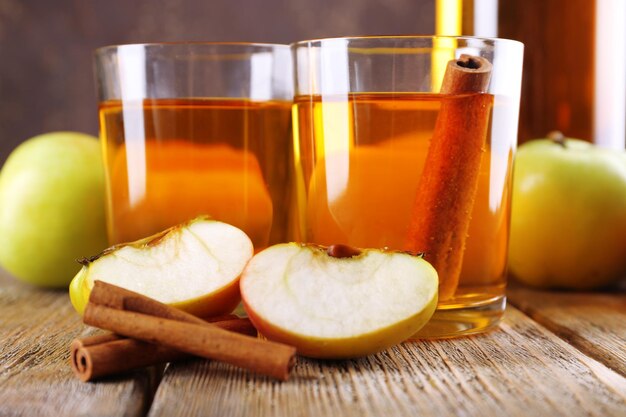 Bodegón con sidra de manzana y manzanas frescas sobre mesa de madera