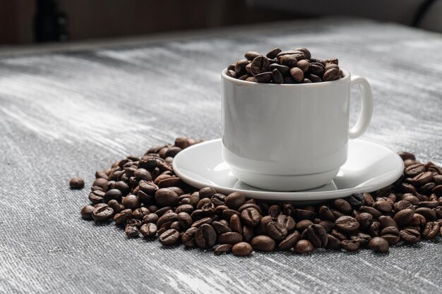 Bodegón con taza y granos de café tostados