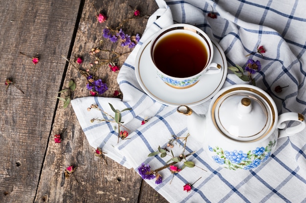 Bodegón con taza de té y mantel en mesa de madera