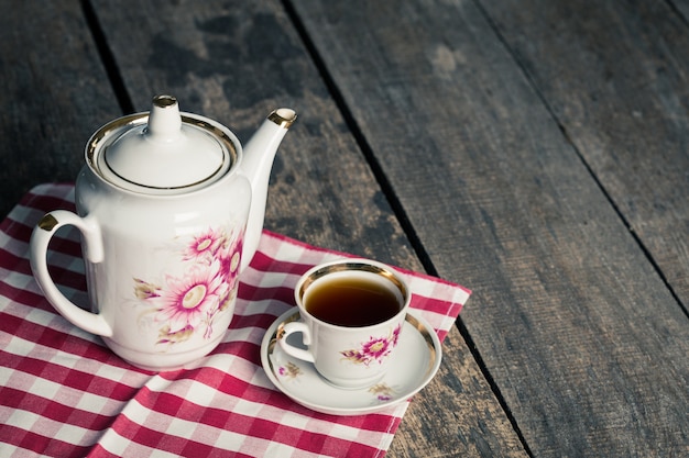 Bodegón con taza de té y mantel en mesa de madera