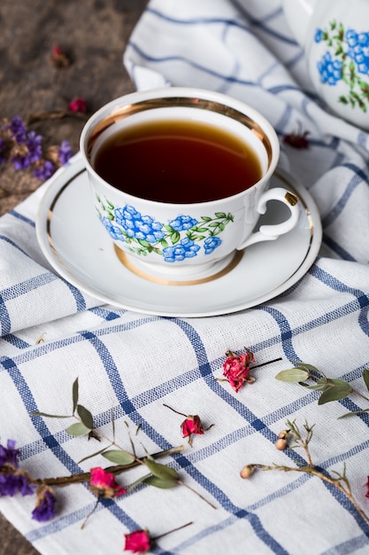 Bodegón con taza de té y mantel en mesa de madera