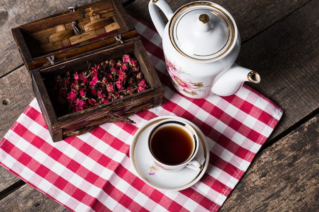 Bodegón con taza de té y mantel en mesa de madera