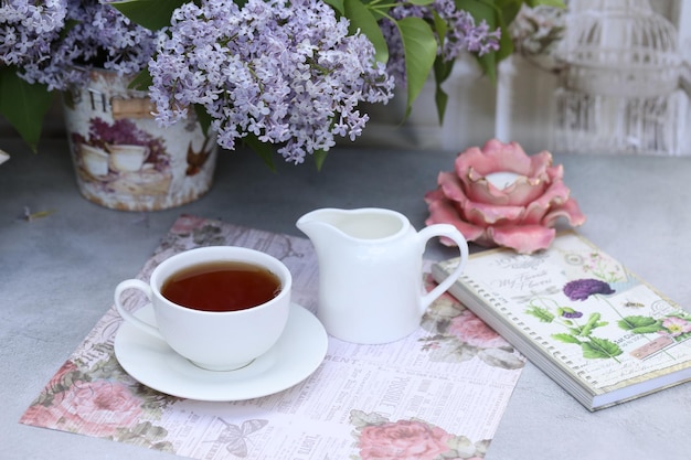 bodegón con taza de té matutino y flores lilas