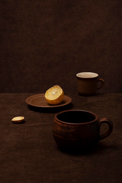 Bodegón con tazas marrones y limón.