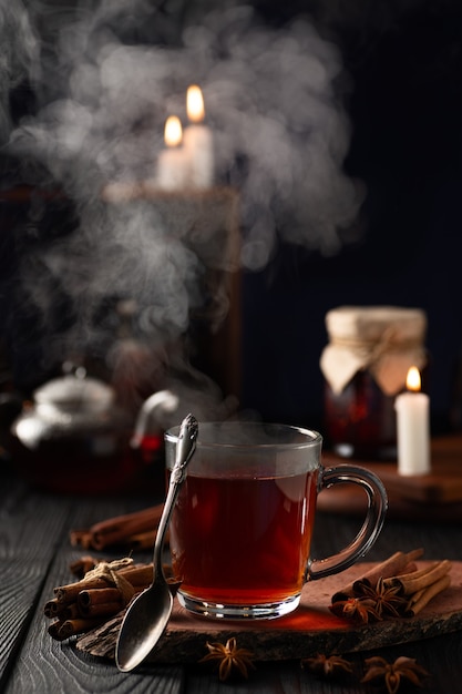 Bodegón con té caliente en un vaso y vapor caliente saliendo del vaso