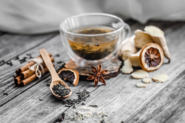 Bodegón con transparente taza de té sobre fondo de madera