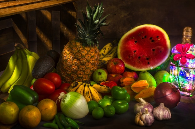 Bodegón con varias frutas y lámpara de botella.