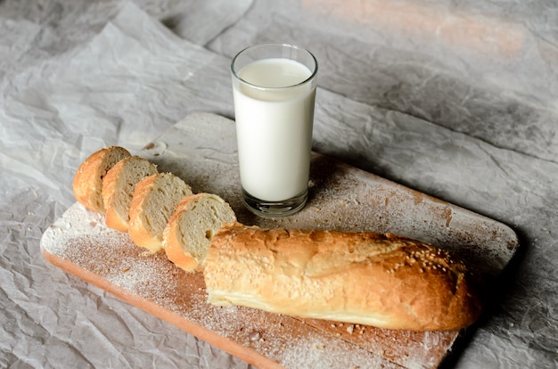 Bodegón de un vaso de leche y pan de molde.