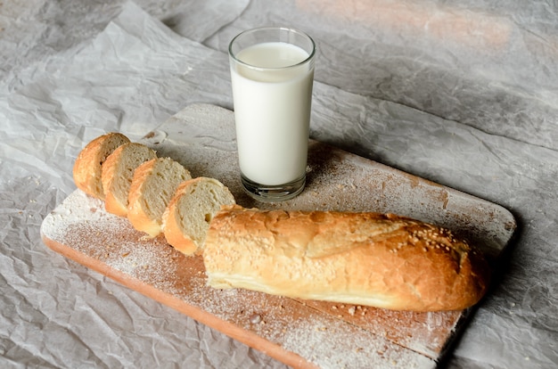 Bodegón de un vaso de leche y pan de molde.